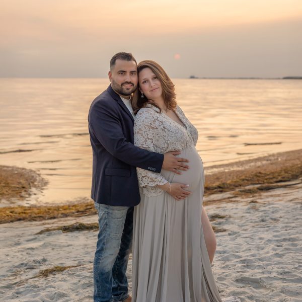 Gravidfotografering på stranden under en otroligt vacker solnedgång.